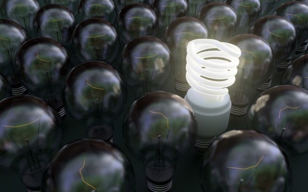 Fluorescent light bulb among dark incadescent bulbs