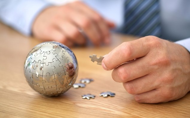 Businessman solving globe puzzle concept for business solutions and strategy