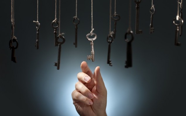 Hand choosing a hanging key amongst other ones.