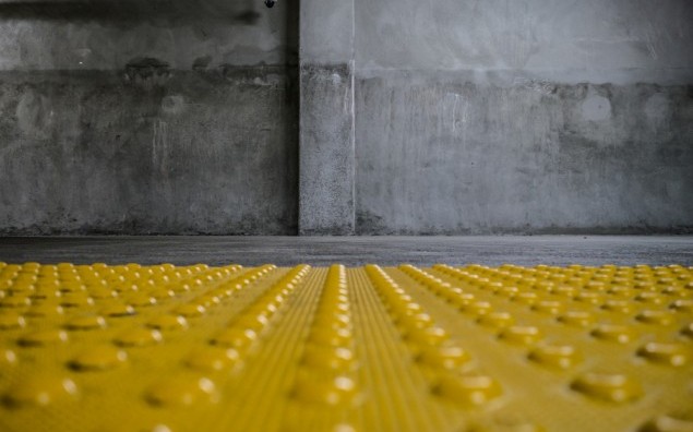 Grunge room interior with safety yellow bumps panel on floor. Copyspace.