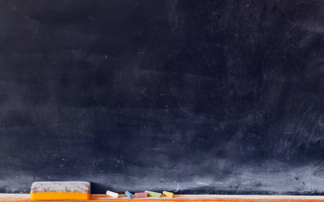 Blank blackboard with colored chalks