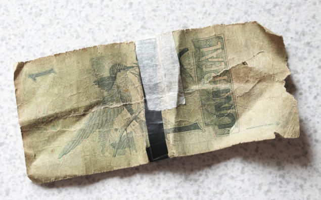 Broken brazilian banknote with background. Real.