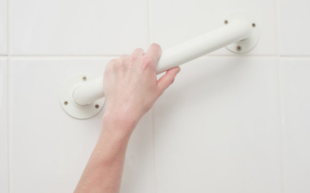 Hand touching handle in bath tub
