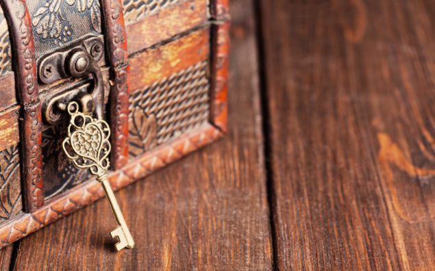 vintage key and old treasure chest on wooden table