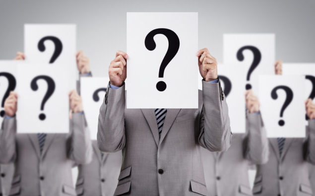 Business colleagues holding question mark signs