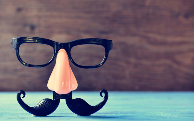 fake mustache, nose and eyeglasses on a blue surface