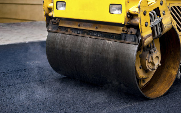 Compact steamroller flatten out the asphalt