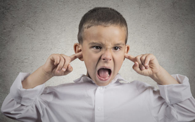 angry pissed off boy plugs his ears with fingers