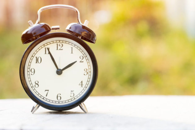 alarm clock on table with green background